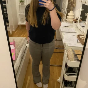 Grå bootcut jeans med stretch - Säljer ett par gråa jeans med bootcut-modell och normal passform. Byxorna har klassisk femficksdesign och är tillverkade i stretchigt material för extra komfort. 