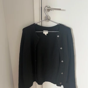 Svart stickad kofta med knappar - Svart stickad kofta från hm i storlek L. Säljer då den är för stor och den är i ganska bra skick.