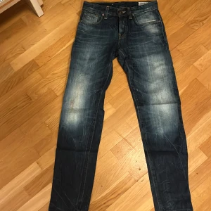 G-Star RAW blå jeans straight fit - Snygga blå jeans från G-Star RAW med slitna detaljer och klassisk femficksdesign. Jeansen har raka ben och en cool tvätt med ljusare partier framtill och bak. Märkespatch i läder baktill i midjan. Perfekta för dig som gillar streetstyle.