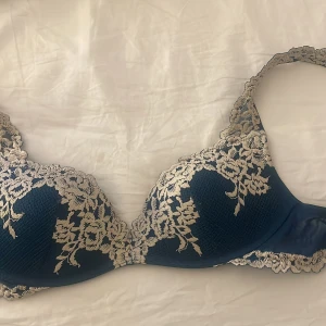 Mörkgrön intimissimi bh med blommönster - Säljer en intimissimi bh med vacker vitt spets och blommönster. Den är knappt använd och liten i storlek men väldigt fint skick💕, hör av er vid funderingar