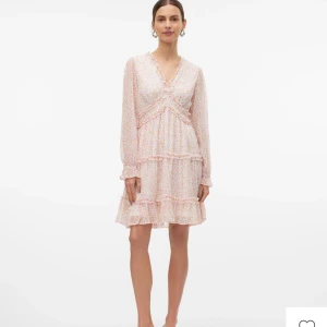 Blommig klänning från Vero Moda - Jättefin klänning från Vero Moda med blommigt mönster. Klänningen har volangdetaljer, v-ringning och långa ärmar. Perfekt för vår och sommar, lätt och luftig. Storlek XS, bara använd en gång💗