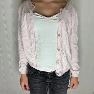 Ljusrosa kofta med knappar - Söt ljusrosa kofta med långa ärmar och knäppning framtill. Koftan är tunn och stickad, perfekt att slänga över en topp. Enkel och stilren design som passar till jeans eller kjol. Säljer pågrund av att den är för liten för mig. Pris kan diskuteras❤️