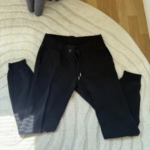 Svarta mjukisbyxor  - Svarta mjukisbyxor från Cubus.  Byxorna har resår och snörning i midjan, muddar nertill och två sidofickor. Är endast använda ett få tal gånger