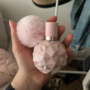 Ariana Grande Sweet Like Candy parfym - Säljer en Ariana Grande Sweet Like Candy Eau de Parfum 50 ml. Flaskan är matt ljusrosa med geometriskt mönster och har en fluffig rosa boll som dekoration. Doften är söt och lekfull, perfekt för dig som gillar fruktiga och godisaktiga toner. Knappast använd !!