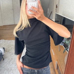 Svart trekvartsärmad polotröja  - Snygg tröja med krage och trekvartsärmar med volang fit