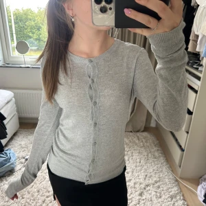 Ljusgrå kofta från 157, storlek S - Supermjuk och stilren ljusgrå kofta från 157 med rund halsringning och knappar hela vägen framtill. Långärmad modell i tunt, stickat material som passar perfekt till lager-på-lager. Enkel att matcha med allt i garderoben.