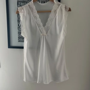 Vit blus - Vit satin blus med spets. Aldrig använd prislappen kvar. Stl onesize men passar S M & L. Nypris 299