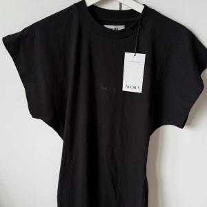 Svart kortklänning från Ávora - Svart klänning från Åvora i modellen DNA Dress. Klänningen har en enkel och stilren design med rund hals och korta, vida ärmar. Materialet är mjukt och känns bekvämt mot huden, perfekt för dig som gillar minimalistisk stil. Prislapp är kvar och klänningen har inga defekter. Storlek S. Säljer då den inte passade mig. Är öppen för byten mot en likadan i storlek XS/XXS. Nypris 1200kr. Går inte ner i pris på denna.🩷