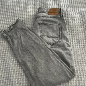 Grå jeans från Jack and Jones , 32/34 - Snygga grå jeans från Jack and Jones i klassisk femficksmodell. Jeansen har raka ben, normal passform. Perfekta för dig som gillar en stilren och avslappnad look.