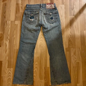 True Religion - Unika True Religion jeans med många snygga detaljer och riktigt nice passform. Mycket bra skick, en skräddare har lagat dem på olika ställen och även stärkt tyget så att de ska tåla mer. Pris kan diskuteras, skriv om du har frågor!