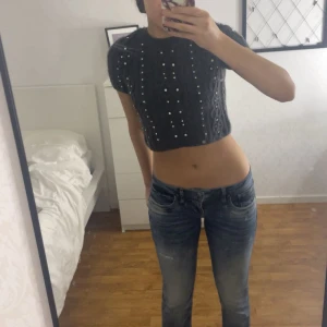 Grå stickad kort topp med diamantdetaljer - Säljer en grå stickad croppad topp med diamantdetaljer från Zara.  Den är både mysig och trendig. Nyskick, aldrig använd! 💓