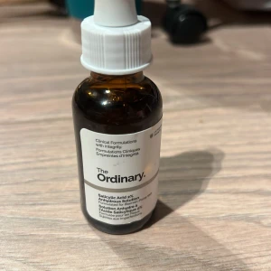 The Ordinary Salicylic Acid 2% Anhydrous Solution - The Ordinarys Salicylic Acid 2% Anhydrous Solution är en effektiv behandling för oren hud. Den kommer i en brun glasflaska med pipett för enkel applicering. Perfekt för att reducera finnar och förbättra hudens textur.