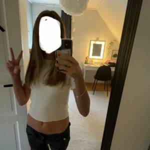 Beige stickad kortärmad topp - Säljer en stilren beige stickad topp med korta ärmar. Perfekt för en avslappnad look. Toppen har en rund halsringning och är gjord i ett mjukt material som känns skönt mot huden. Säljer pga att den är för liten.