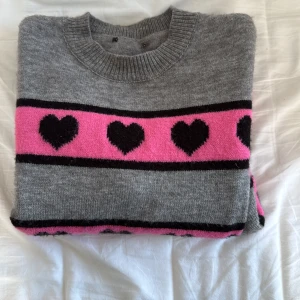 Grå/ Rosa tröja ifrån okänt märke - Säljer denna super söta tröja från okänt märke då lappen är borttagen men köpt på byus. Säljer då den inte än ända längre. Perfekt passform. Skulle gissa att tröjan är i strl. Xs/s