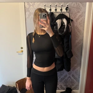 Fest topp - Snygg svart fest topp med ”genomskinliga” armar. Väldigt tight så den sitter åt väldigt snyggt. Går även att använda kanske på en middag eller på stan. Är lite sönder i kragen men inget som syns.