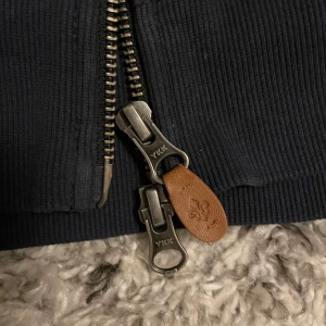Mörkblå jacka från Morris - Säljer en stilren mörkblå jacka från Morris. Jackan har en dragkedja framtill och är tillverkad i ett ribbat material. Perfekt för en casual look. Extremt bra skick