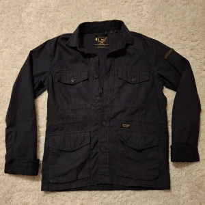 Marinblå Superdry Overshirt - Tja, säljer denna feta overshirt från märket Superdry. Tröjan är i storlek XS men passar S. Endast använt den ett fåtal gånger så den är i ett mycket bra skick! Nypris 900 kr!