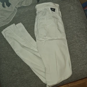 Vita jeans  - Snygga vita jeans med en klassisk design. Byxorna har en rak passform och är tillverkade i ett bekvämt material. Perfekta för en stilren look.
