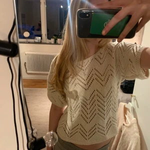 Beige stickad topp - Så fin cremevit stickad topp med korta ärmar och ett snyggt hålmönster, lite längre där bak.🤍🤍Står ingen storlek i, men den sitter bra på mig som vanligtvis har S