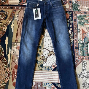  G-Star RAW slim jeans - Snygga blå jeans från G-Star RAW, modell 3301 Slim. De har en klassisk femficksdesign och en slim passform. Perfekta för en stilren look med en modern touch. Helt nya med tags nypris: 1100
