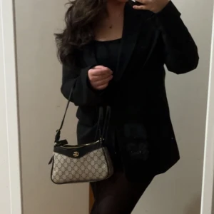 Mönstrad axelväska med svarta detaljer - Använd 2 gånger som max. Väldigt fin kvalitet! 