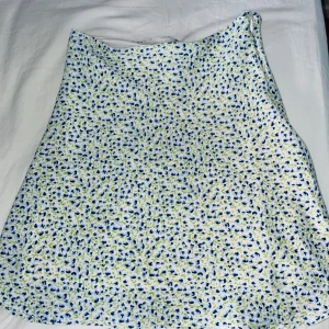 Blommig kjol från H&M Divided - Fin blommig kjol från H&M Divided. Kjolen har en dragkedja på sidan. Den skulle passa perfekt för sommaren. Jag har använt denna kjol en gång. Priset kan diskuteras!! Storlek 32/ XXS-XS💗