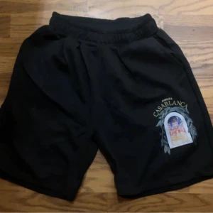 Svarta shorts med tryck - Snygga svarta shorts med ett coolt tryck på ena benet. Perfekta för en avslappnad stil. De har en elastisk midja för extra komfort.