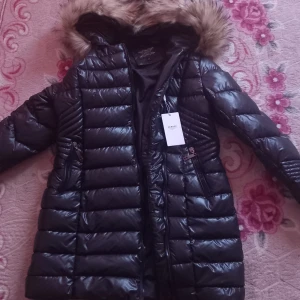 Svart pufferjacka med pälsdetaljer från Garoff. Pris kan diskuteras. - Säljer en snygg svart pufferjacka från Garoff med pälsdetaljer på huvan. Jackan har en glansig yta och dragkedja framtill. Perfekt för kyliga dagar!