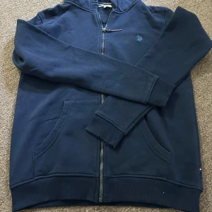 Mörkblå hoodie från U.S. Polo Assn. - Hoodie med dragkedja och huva. Sparsamt använd för en avslappnad stil.