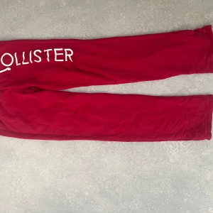 Röda mjukisbyxor från Hollister - Snygga röda mjukisbyxor från Hollister med vit logga och siffrorna '1922' tryckta på sidan. Perfekta för en avslappnad stil. Byxorna har en bekväm passform och är gjorda i mjukt material.