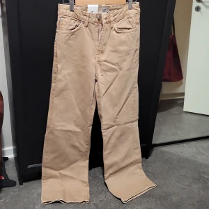 Beige byxor från 157 - Byxorna har en rak passform med dragkedja och knapp framtill. Perfekta för en avslappnad look.