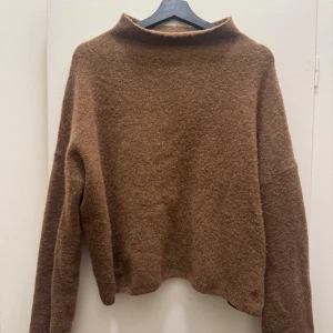 Tröja från Filippa K - Säljer en mysig tröja från Filippa K i färg kamel. Tröjan har en enkel design med långa ärmar och en mjuk finish. Halvpolo krage