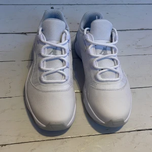 Vita sneakers från Nike Jordan - Snygga vita sneakers från Nike Jordan med klassisk design och snörning. Skorna har en stilren look med en bekväm sula och är perfekta för en sportig stil. De är i storlek 41 herr och kommer i originalkartong.
