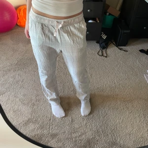 Ljusrosa pyjamasbyxor från Kappahl - Säljer ett par ljusrosa pyjamasbyxor från Kappahl. Byxorna har en bekväm elastisk midja med snörning och är perfekta för en avslappnad stil. De är tillverkade i ett lätt och luftigt material som passar bra för att ha en skön men stilig look. Andvänd 1 eller 2 gånger. Pris går att diskutera!💕