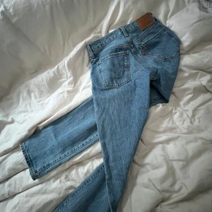 Blå jeans från Levi's - Snygga blå lågmidjade jeans från Levi's med klassisk femficksdesign och en bekväm passform. Perfekta för en avslappnad stil. De har en knappgylf och är tillverkade i slitstarkt denim.   Tyvärr är dom försmå för mig och därför säljer jag dom 