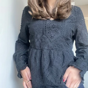Svart blus  - Svart blus från Y.A.S som är lätt v ringad med volang nertill. Hör gärna av dig vid eventuella frågor🫶.