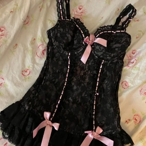 Svart spetskorsett från La Senza -  svart spetskorsett från La Senza med rosa detaljer och rosetter. Det står ingen storlek eller kupa men skulle säga att det är S/M