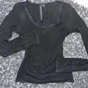 Svart långärmad topp med spetsdetalj - Säljer en stilren svart långärmad topp från 157 med en fin spetsdetalj runt halsringningen. Perfekt för en elegant och enkel look. Toppen är i en mjuk och bekväm bomullsmix. Matrialet är stretchigt🩷
