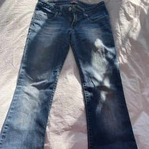 Blå bootcut jeans - Snygga blå bootcut jeans med klassisk femficksdesign och ljus tvätt. Perfekta för en avslappnad stil. De har en knapp och dragkedja framtill.