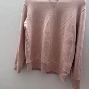 Rosa sweatshirt - Säljer en stilren rosa sweatshirt med långa ärmar och ribbade muddar vid ärmslut och nederkant. Perfekt för en avslappnad look.Är i storlek 13 år 