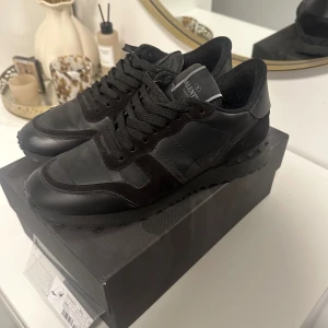 Svarta sneakers från Valentino - Snygga svarta sneakers från Valentino Garavani. Modellen heter Rockrunner. De har en unik detalj med nitar på hälen. Knappt använda så är så gott som nya! 