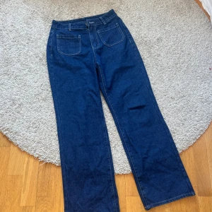 Mörkblå jeans - Snygga mörkblå jeans i storlek S. Byxorna har en klassisk design med raka ben och framfickor. Perfekta för en avslappnad stil. Defekt nere vid kanten av benet. Liten upprivning