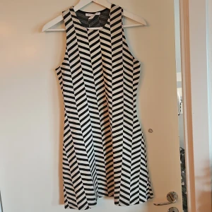 Svartvit ärmlös klänning - Snygg svartvit klänning med ett iögonfallande randigt mönster. Klänningen är ärmlös och har en klassisk A-linjeform som ger en stilren look. Perfekt för en dag ute eller en kväll med vänner. 🖤🤍