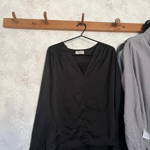 Chiquelle blus - Svart Chiquelle Blus i siden material, säljer för att jag rensar garderoben och hade nästan glömt att jag hade denna 😅 så skulle max säga att denna är andvänd 1-3 gånger. Denna funkar lika bra till en fin middag som till vardags, skulle även säga att denna sitter som ett mellanting mellan storlekarna M och S❤️ skriv för frågor eller funderingar🥰