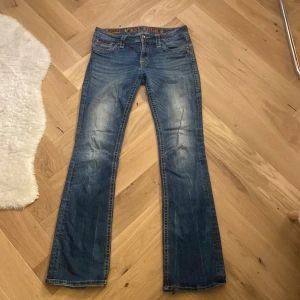 Blå jeans från Rock Revival - Snygga blå jeans från Rock Revival med broderade detaljer på bakfickorna. De är lowwaist samt bootcut.  Skriv om du har någon fråga ☺️