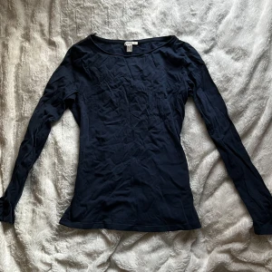 Mörkblå långärmad topp från Esprit - Säljer en stilren mörkblå långärmad topp från Esprit. Perfekt för en avslappnad look. Toppen har en enkel design med rund halsringning.