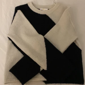 Svart och vit stickad tröja från Gina Tricot - Säljer en nästan helt oanvänd stickad tröja från Gina Tricot i svart och vitt med ett diagonalt mönster. Tröjan har långa ärmar och en rund halsringning. Perfekt för att hålla sig varm och stilren under kyligare dagar. Tröjan är i storlek 146-152