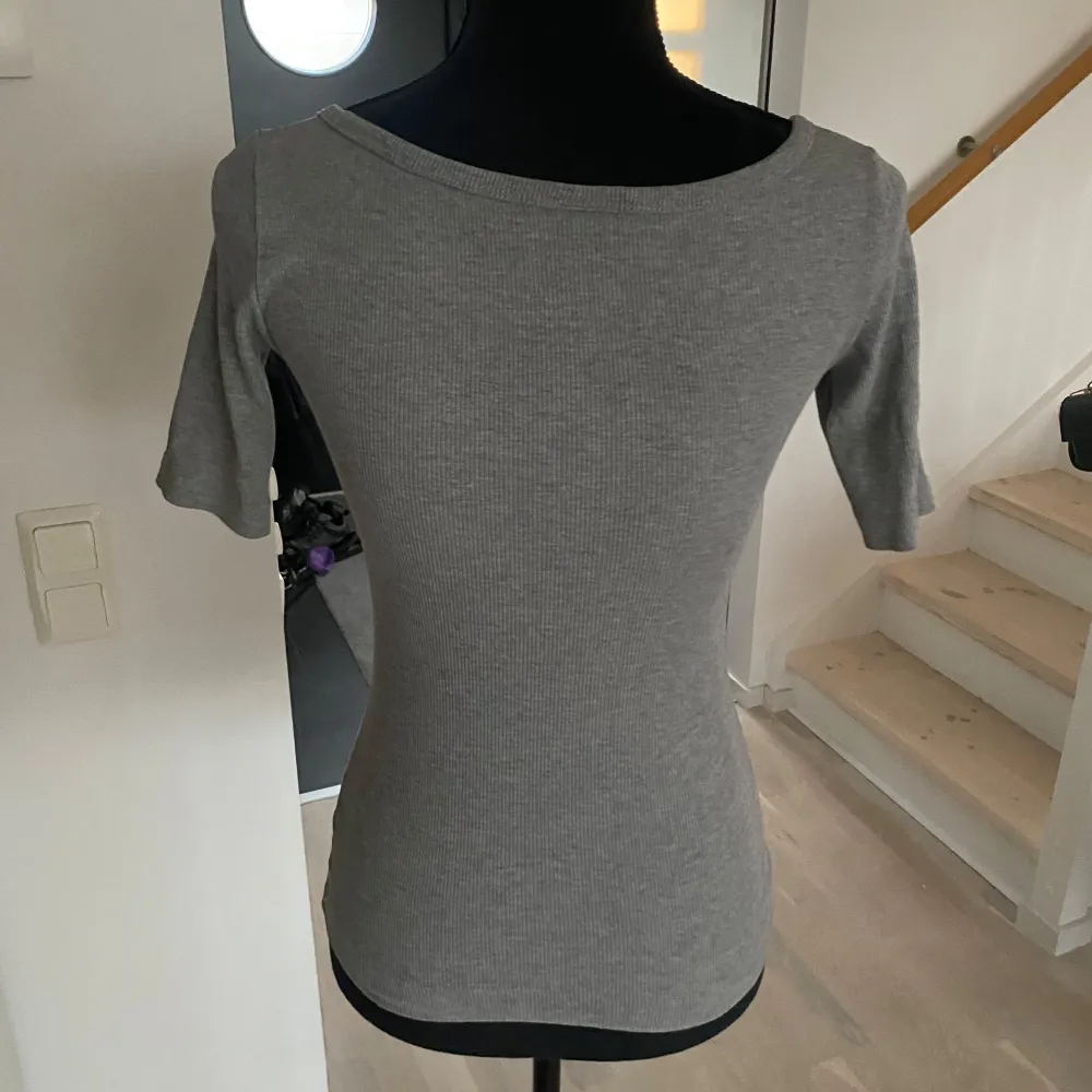 Snygg grå ribbad topp med trekvartsärm och rund halsringning. Perfekt för en stilren och bekväm look.. Yläosat.