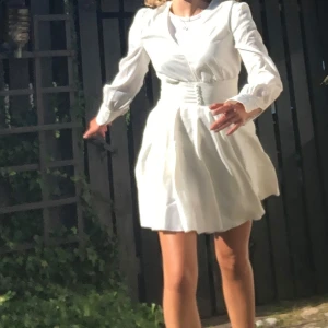 studentklänning - Elegant vit klänning med långärmad klänning som påminner om Adoore Florence dress. Klänningen har en v-ringad hals, och på första bilden är den med en t-shirt under🤍 Använd en gång, krämvit