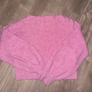 Rosa stickad tröja från Vero Moda - Mysig rosa stickad tröja från Vero Moda. Tröjan har långa ärmar och en enkel design som gör den lätt att matcha med olika outfits.